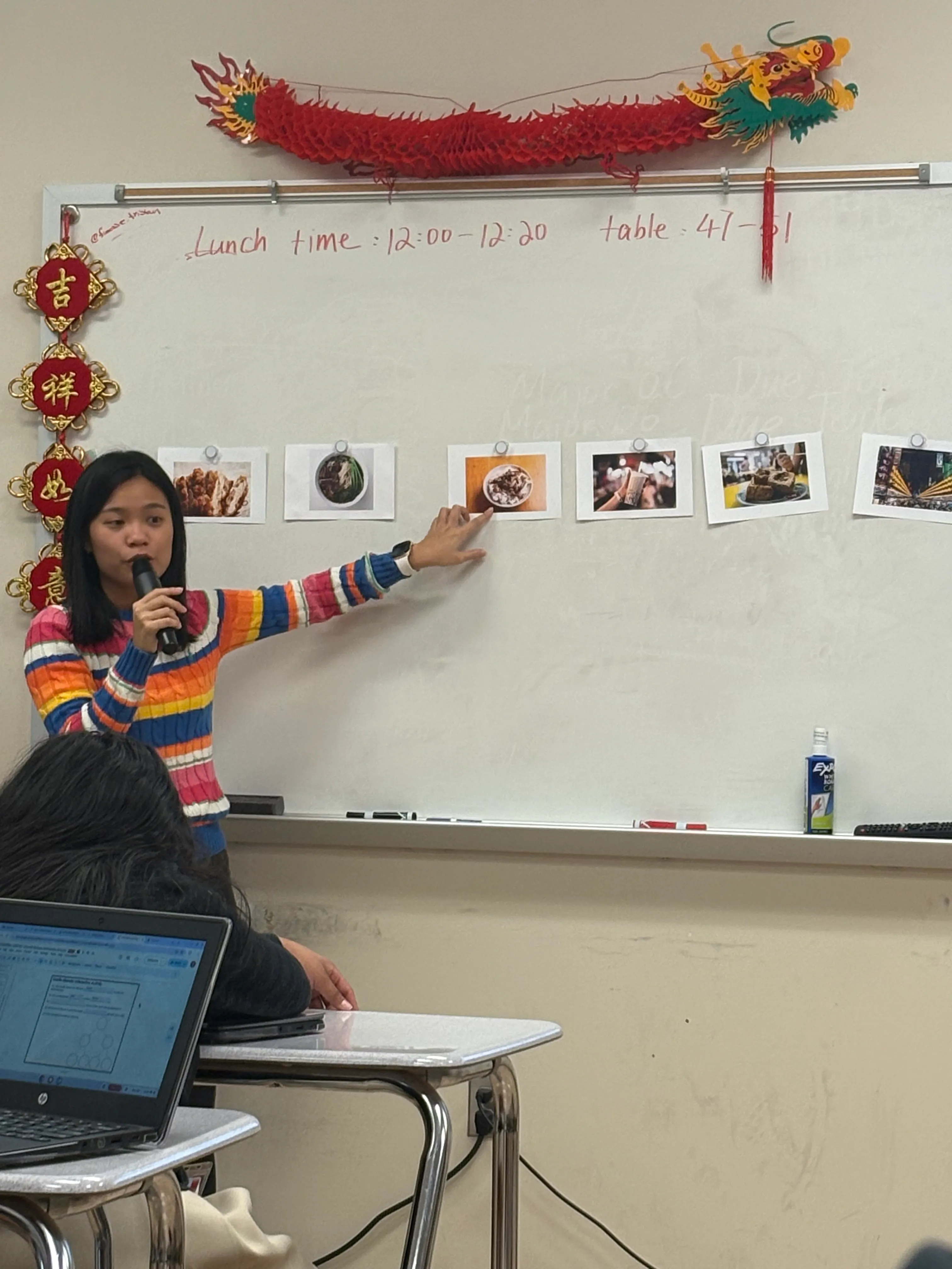 Yi Ling Pan points to food photographs during a classroom lesson.