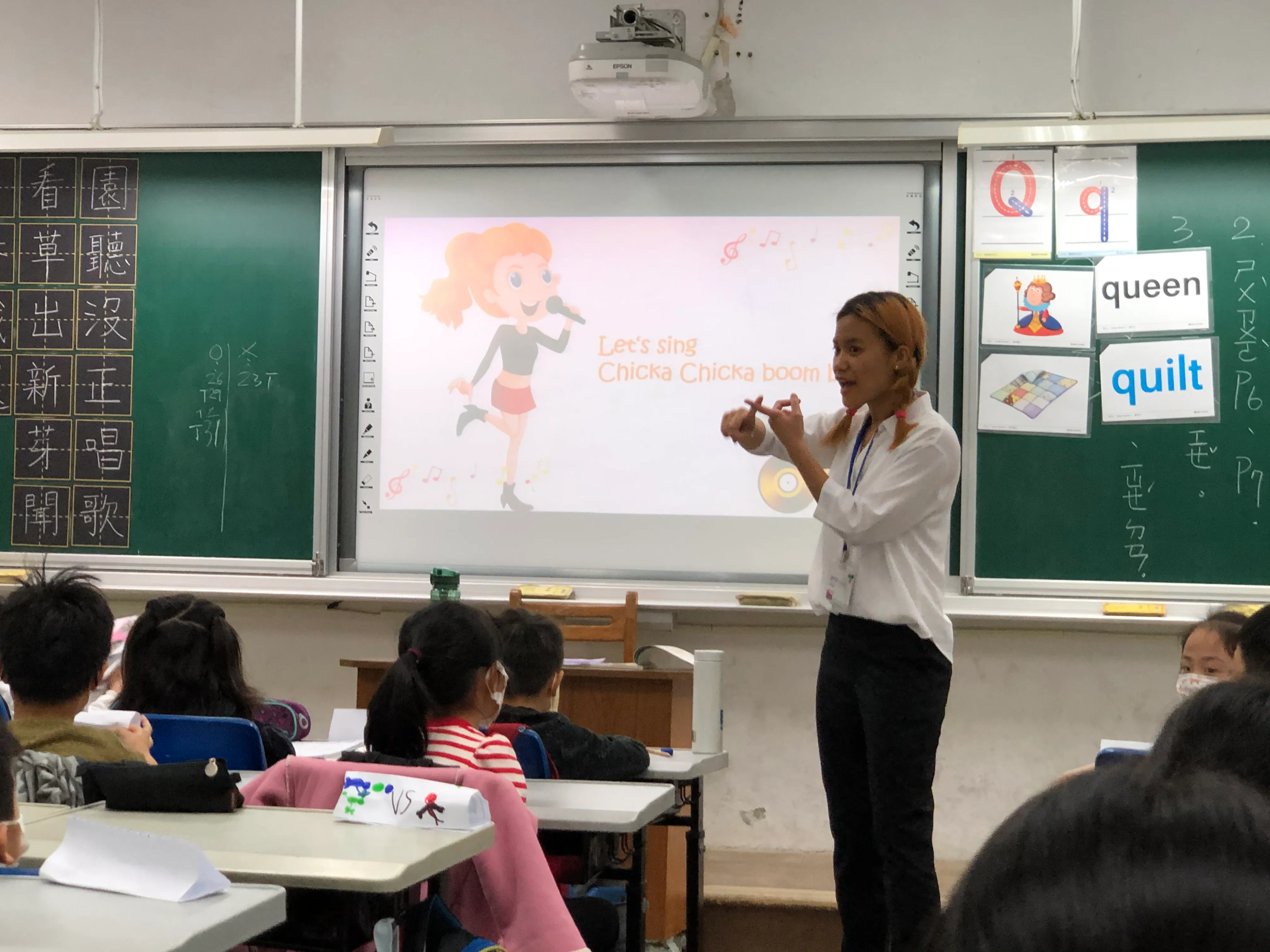 Yi Ling Pan leads a lesson while students watch from their desks.
